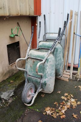une brouette verte garée devant un immeuble