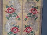 un vieux chemin de table jaune et rouge orné de motifs floraux