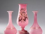 three pink vases sitting on top of a table next to each other