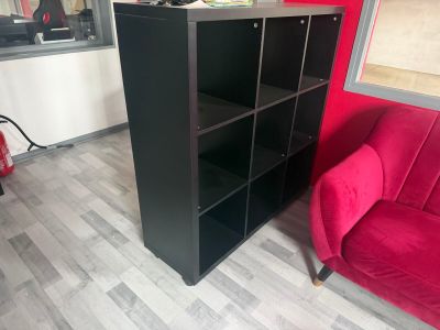 a red couch and a black bookcase in a room
