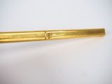 an image of a gold pen sitting on top of a white table
