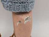 a close up of a person ' s leg with a knitted boot