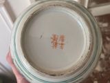 a person holding a bowl with a chinese writing on it