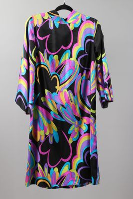a black and multicolored dress hanging on a hanger