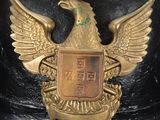a black helmet with a gold eagle emblem on it