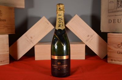 a bottle of champagne sitting on a table next to wooden boxes