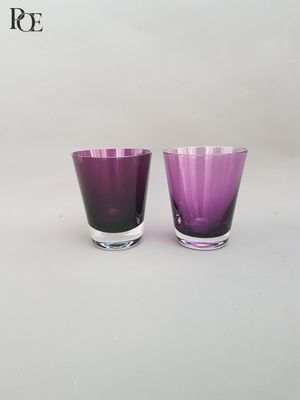 une paire de verres à eau en verre violet sur fond blanc
