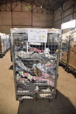 une cage métallique remplie d'une multitude d'objets, située à l'intérieur d'un entrepôt