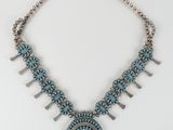 a necklace with turquoise stones and silver beads on a white background