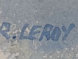 a picture of a blue and white sign on a cement wall