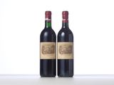 two bottles of red wine sitting next to each other on a table