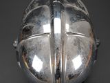 a silver helmet on a black surface with a red star on it