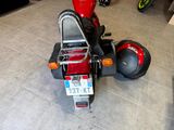 a red motorcycle parked in a garage with a helmet on the back