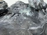 a statue of a bird sitting on top of a rock