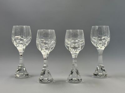 quatre verres à vin transparents posés sur une table
