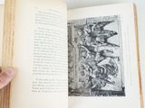someone is holding an open book with a picture of a group of people on it