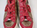a pair of brown and red sneakers on a white surface