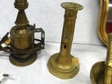 three brass candles and a mirror on a table