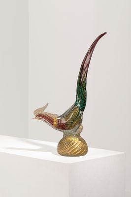 une sculpture en verre représentant un oiseau perché sur un socle