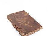 an old book that is sitting on a white surface