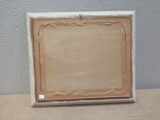 an old picture frame sitting on top of a table next to a wall