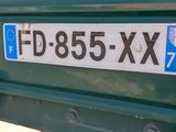 a green bus that has a sign on the back of it