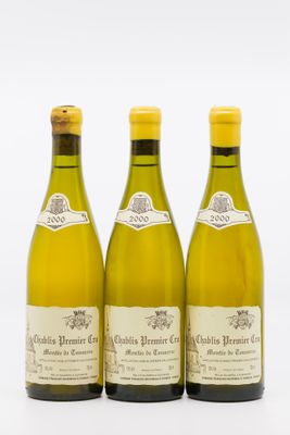 trois bouteilles de vin blanc posées l'une à côté de l'autre sur une surface blanche