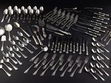 a large collection of silverware on a black table