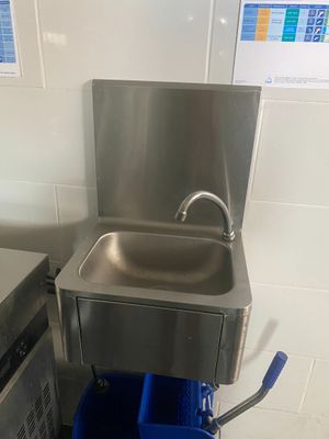 un seau bleu posé à côté d'un lavabo dans une salle de bains