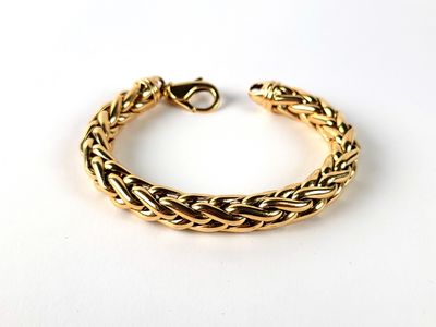 a close up of a gold bracelet on a white surface