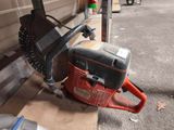 a chainsaw sitting on the ground next to a garage door
