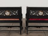 two black chairs with red cushions and a clock on the back of them