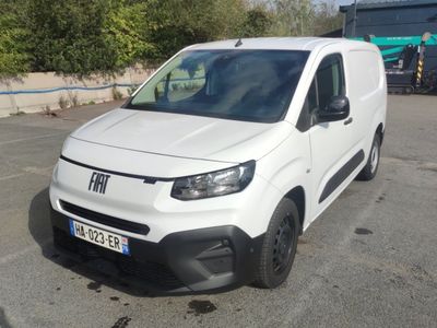 the white van is parked in a parking lot near a building