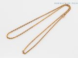 a close up of a gold necklace with a chain on a white background