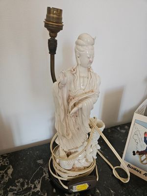 a statue of a woman holding a candle on a table