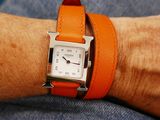 a person wearing an orange watch on their wrist