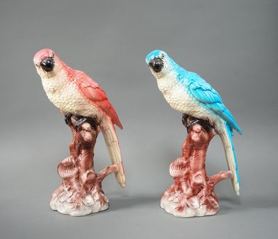 two figurines of parrots sitting on a tree branch