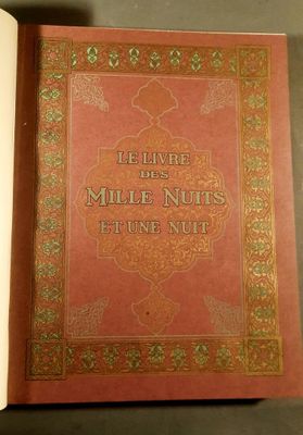 le livre est ouvert sur une table ; il a une couverture rouge et des bordures dorées
