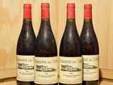 trois bouteilles de vin sont posées sur un tonneau devant un mur en bois