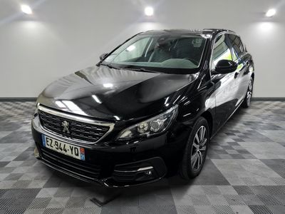 La voiture noire est garée sur le sol à damier du garage.