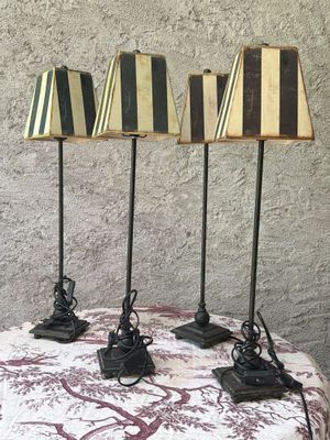 trois lampes noires et blanches posées sur une table recouverte d'une nappe rouge et blanche