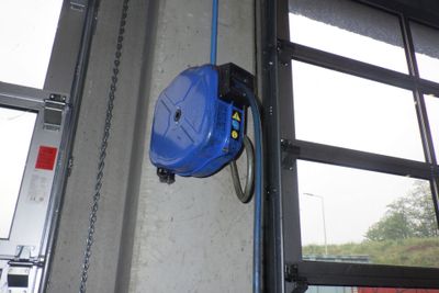 un tuyau bleu fixé sur le côté d'une porte de garage