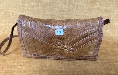 un sac à main en cuir marron muni d'une étiquette, posé sur un canapé