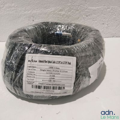 une bobine de fil noir enveloppée de plastique posée sur une table