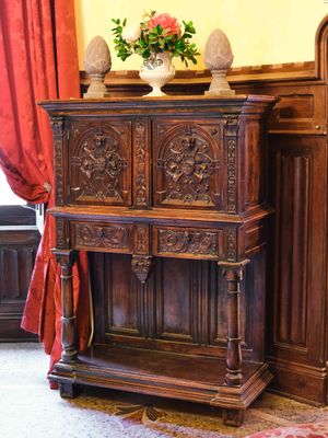 une armoire en bois sur laquelle est posé un vase de fleurs