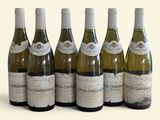 six bottles of wine are lined up in a row on a white surface