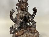 une statue en bronze représentant une femme assise sur une table