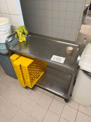 a yellow basket sitting on the floor next to a trash can