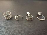 three silver rings on a black leather surface with a price tag