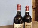two bottles of wine sitting on a wooden table